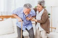 Retired Asian senior elderly husband pain from heart attack disease or illness with serious or worried wife take care at home. Royalty Free Stock Photo