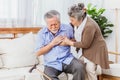 Retired Asian senior elderly husband pain from heart attack disease or illness with serious or worried wife take care at home. Royalty Free Stock Photo