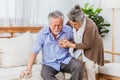 Retired Asian senior elderly husband pain from heart attack disease or illness with serious or worried wife take care at home. Royalty Free Stock Photo