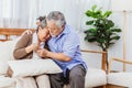 Retired Asian senior elderly wife pain from heart attack disease or illness with serious or worried husband take care at home. Royalty Free Stock Photo