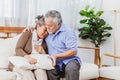 Retired Asian senior elderly wife pain from heart attack disease or illness with serious or worried husband take care at home. Royalty Free Stock Photo