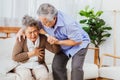 Retired Asian senior elderly wife pain from heart attack disease or illness with serious or worried husband take care at home. Royalty Free Stock Photo