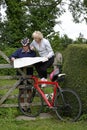 Retired couple on a cycle ride reading their map Royalty Free Stock Photo