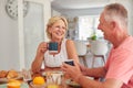 Retired Couple At Home In Kitchen Eating Breakfast Together Royalty Free Stock Photo