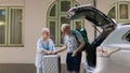 Retired couple loading voyage luggage in car trunk Royalty Free Stock Photo
