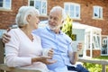 Retired Couple Sitting On Bench With Hot Drink In Assisted Living Facility Royalty Free Stock Photo