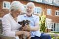 Retired Couple Sitting On Bench With Pet French Bulldog In Assisted Living Facility Royalty Free Stock Photo