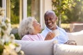 Retired Couple Sitting Outdoors At Home Having Morning Coffee Together Royalty Free Stock Photo