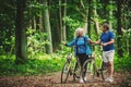 Retired couple walking with bikes in the forest. Royalty Free Stock Photo