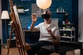 Retired creative artist using virtual reality goggles to visualize model for inspiration