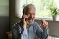 Retired elderly man conversing on telephone joking laughing having fun Royalty Free Stock Photo