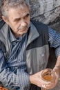 Retired elderly man sits on concrete staircase, drinks beer and thinks about his problems Royalty Free Stock Photo