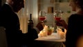Retired elegant couple toasting holding wine glasses, romantic dinner candles Royalty Free Stock Photo