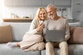 Retired european couple spending time at home, using gadgets Royalty Free Stock Photo