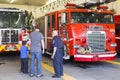 Retired fireman standing with father and son visiting Fire Station