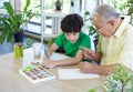 Retired grandfather teach grandson to draw and color during the holidays. Enjoy leisure weekend at home. Stress free concept