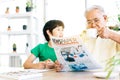 A retired man in casual clothes is concerned with reading a newspaper about COVID-19 news and drinking coffee. Royalty Free Stock Photo