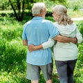 Retired man hugging happy senior wife in green park Royalty Free Stock Photo
