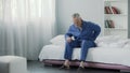 Retired man sitting in bed and feeling terrible pain in back, health and illness