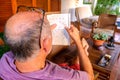 Retired man spends his time solving boring crosswords on the porch of his house