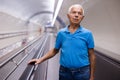 Retired man walking down the escalator to metro station Royalty Free Stock Photo