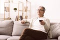 Retired man watching tv with remote control Royalty Free Stock Photo