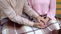 Retired man covering wife hands, pensioner couple resting together in garden