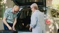 Retired people loading voyage baggage and trolleys inside vehicle Royalty Free Stock Photo