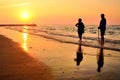 Retired people walking on the beautiful morning beach during sunrise Royalty Free Stock Photo