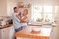 Retired Romantic Couple Dancing In Kitchen At Home Together Royalty Free Stock Photo