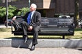 Unemotional Adult Senior Businessman Sitting On Bench