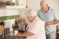 Retired Senior Couple In Kitchen Making Hot Drink Together Royalty Free Stock Photo