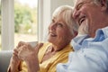 Retired Senior Couple Sitting On Sofa At Home Drinking Coffee And Watching TV Together Royalty Free Stock Photo