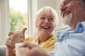 Retired Senior Couple Sitting On Sofa At Home Drinking Coffee And Watching TV Together Royalty Free Stock Photo