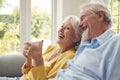 Retired Senior Couple Sitting On Sofa At Home Drinking Coffee And Watching TV Together Royalty Free Stock Photo