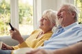 Retired Senior Couple Sitting On Sofa At Home With Remote Control Watching TV Together Royalty Free Stock Photo