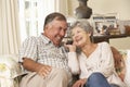 Retired Senior Couple Sitting On Sofa Talking On Phone At Home Together Royalty Free Stock Photo