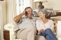 Retired Senior Couple Sitting On Sofa Talking On Phone At Home Together Royalty Free Stock Photo