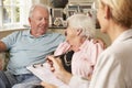 Retired Senior Couple Sitting On Sofa Talking To Financial Advisor Royalty Free Stock Photo