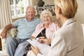 Retired Senior Couple Sitting On Sofa Talking To Financial Advisor Royalty Free Stock Photo