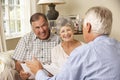 Retired Senior Couple Sitting On Sofa Talking To Financial Advisor Royalty Free Stock Photo