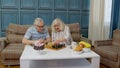 Retired senior couple talking drinking tea, playing chess in modern living home room lounge together Royalty Free Stock Photo