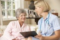 Retired Senior Woman Having Health Check With Nurse At Home