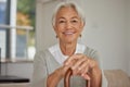 Retired senior woman relaxing at home. Happy smiling old woman holding walking cane and looking at the camera with Royalty Free Stock Photo