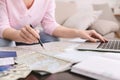 Retired woman planning her worldwide trip with map and laptop