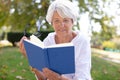 retired woman reading book at park Royalty Free Stock Photo