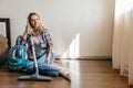 Woman sitting on the floor at bedroom after hoovering