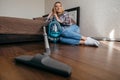 Woman sitting on the floor at bedroom after hoovering