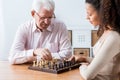 Retiree and caregiver playing chess Royalty Free Stock Photo