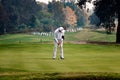 Retiree man putting on golfing green